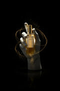 Ego Aurum — Mano de mármol sosteniendo frasco Aureum, iluminación dramática sobre fondo negro.