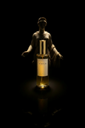 Nyx — Frasco Aureum con silueta escultórica femenina emergiendo de la oscuridad, luz dorada desde abajo.